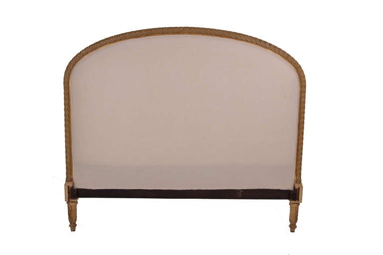 Antique bed from France, late 19th century. Upholstered headboard with intricately carved wood frame. Carved wood footboard & side rails.  Front & back of headboard is newly upholstered in a natural colored muslin, with double welting. Painted