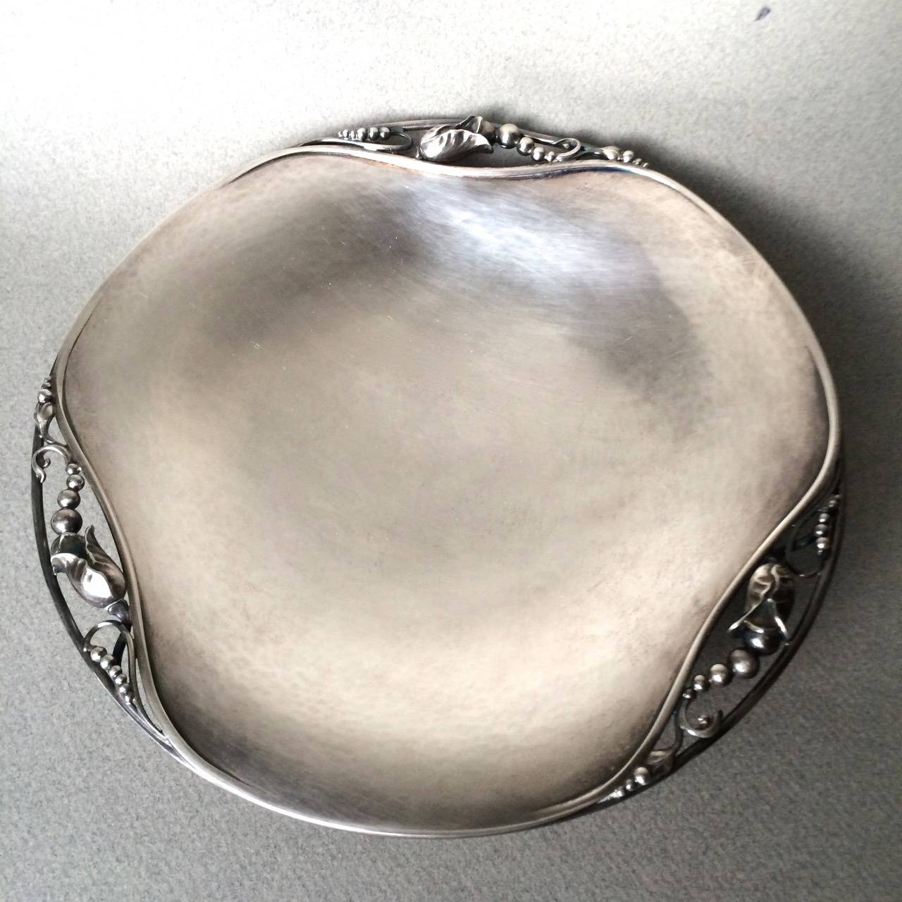 Georg Jensen blossom round footed dish no. 2A.

Three blossom motifs. Very heavy.

Excellent original condition with visible hand hammering. Measures: 7.5