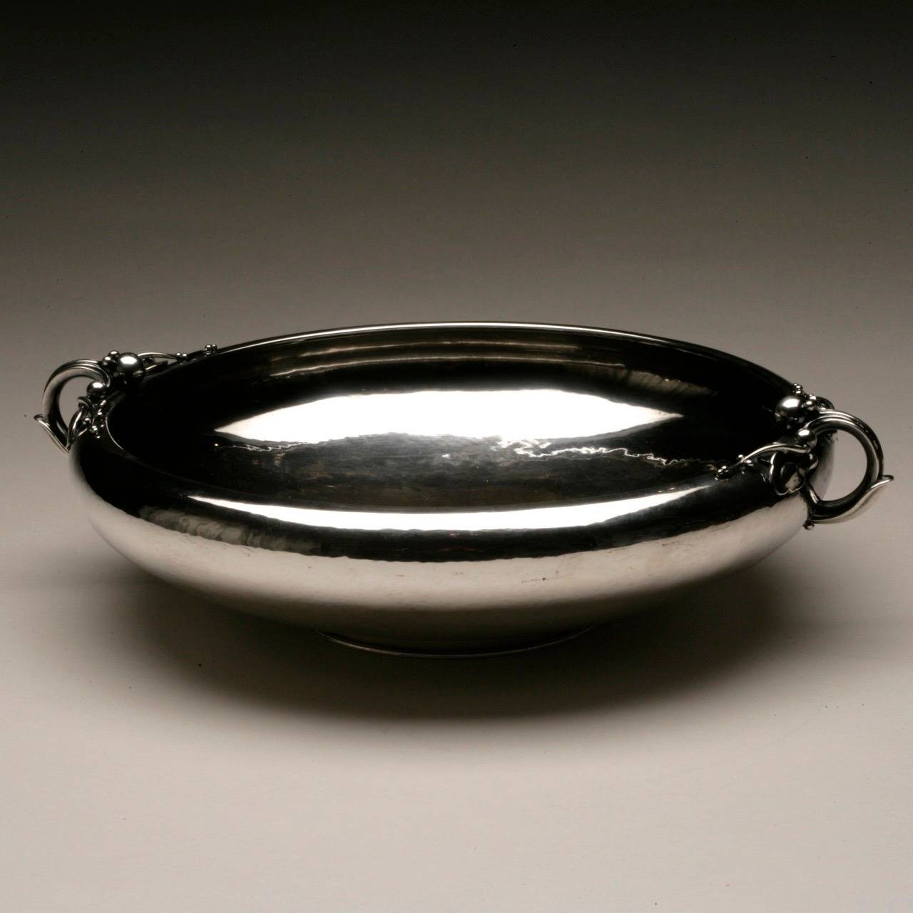 Georg Jensen large centerpiece bowl No. 625B.

Exceptional, large, two handled centerpiece bowl with exquisite detail of leaf and pod in stem. Heavy, sterling silver with lightly hammered surface.

This was Georg Jensen's last design.

Georg