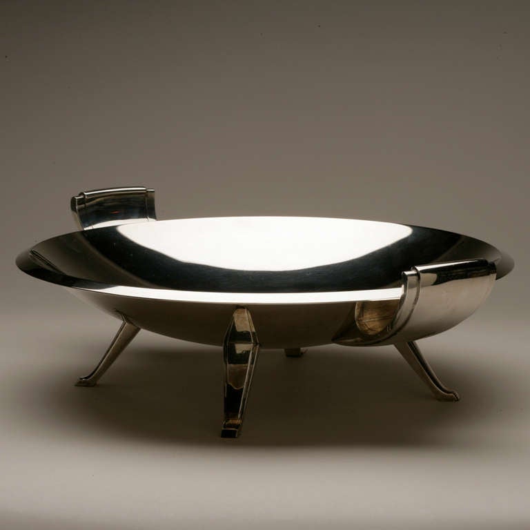 Tiffany & Co. Large Mid-Century Centerpiece Bowl designed by Oscar Riedener in 1952. 

Impressive scale and weight, saucer shape with sweeping tapered handles and feet. 96 ounces.

A similar example can be seen at the Carnegie Museum of Art .