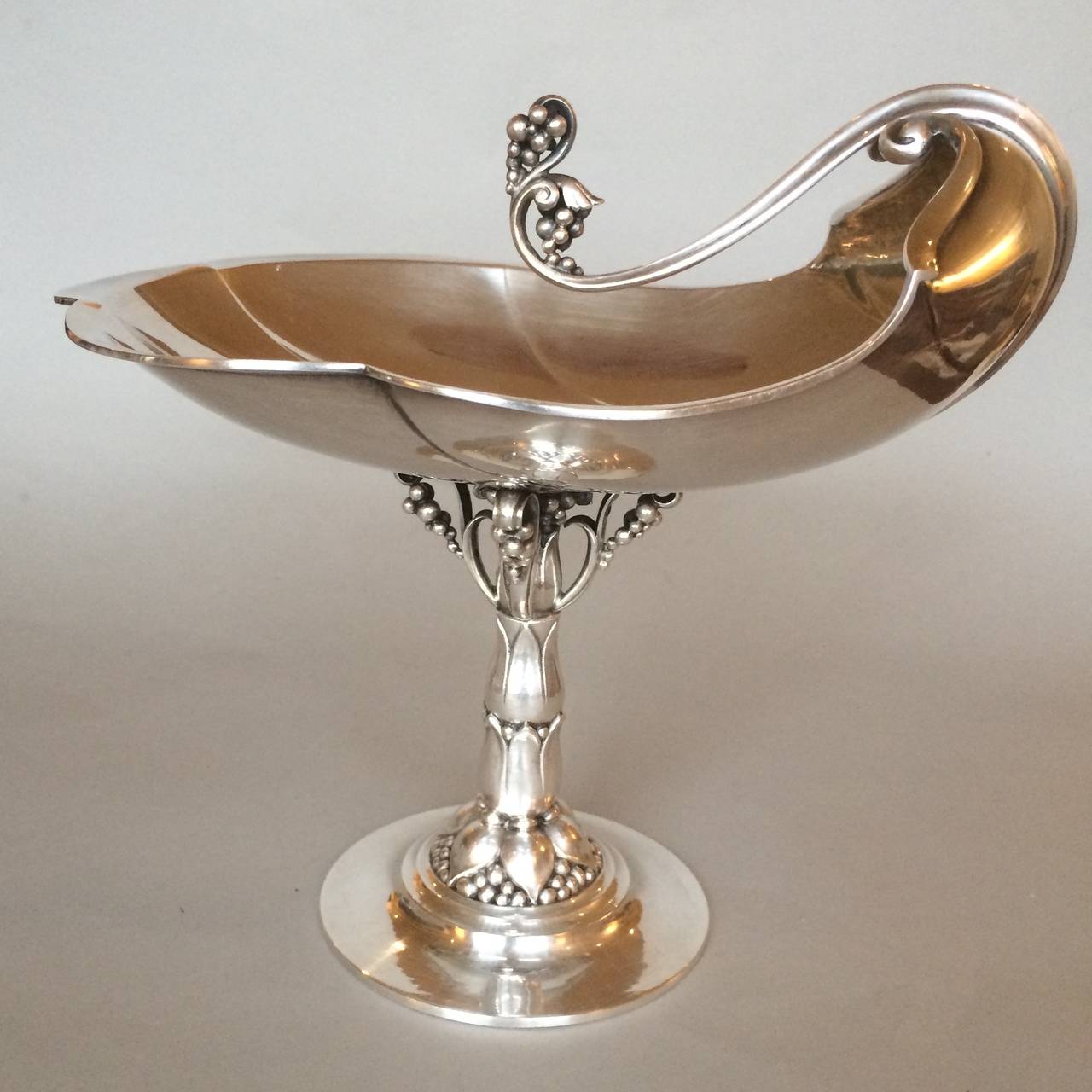 Georg Jensen compote, no. 285B.
Designed by Georg Jensen in 1918.
Stepped spreading base, rises to a foliate stem topped by openwork scrolls and pendant grapes, supporting a shell-form bowl.
Ultra-rare, especially in this size.
Excellent