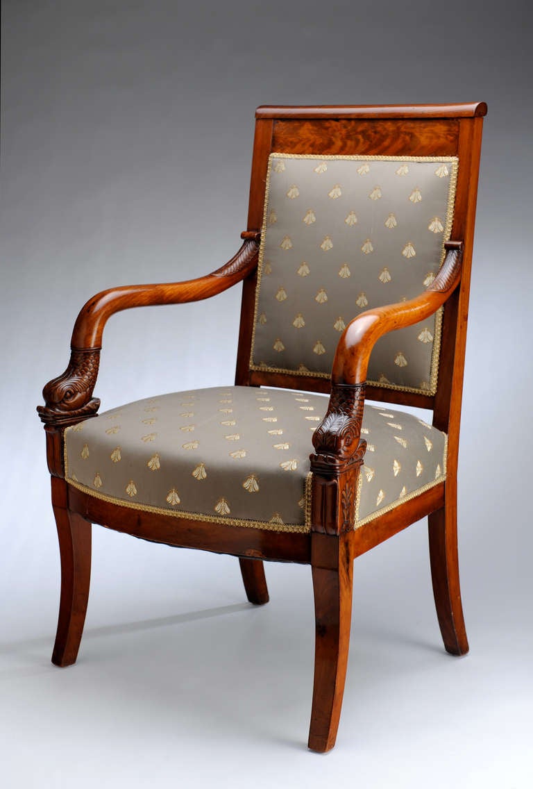 A beautifully understated armchair with extraordinary carved dolphin motif armrests.  

After Napoleon's fall in 1814, the French wanted a return to their former comfortable lives. King Charles X was reinstated and French furniture design
