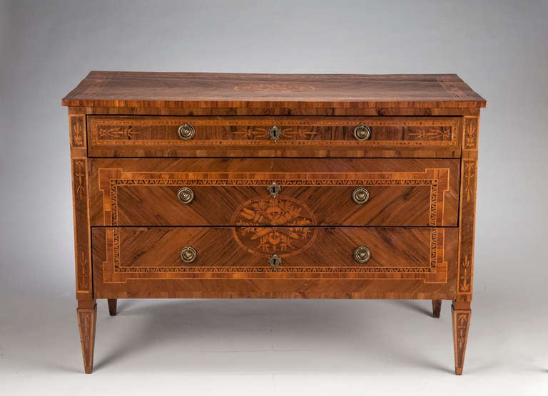 This Roman, 18th c. Commode is similar stylistically to works by Giuseppe Maggiolini who was a cabinet-maker in Milan in the later 18th century and whose cabinets featured detailed marquetry vignettes and complicated borders in a blocky neoclassical