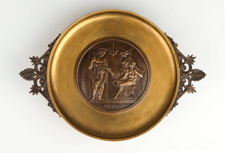 A 19th century bronze tazza, signed E. Picault, of circular form with pierced acanthus and pine cone handles, centered with a relief depicting Hector admonishing his brother Paris with Helen of Troy, raised on shaped bracket feet.