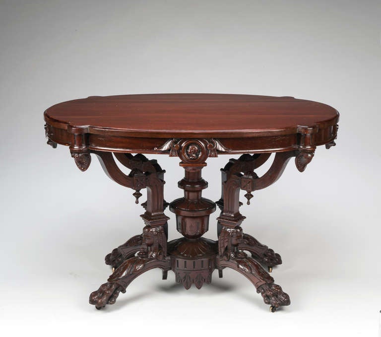 A Fine American Renaissance Carved Rosewood Center Table, mid-19th c., by John Jelliff, Newark, New Jersey.  This ornate example features carved busts in the egyptian manner, carved clawed feet ending in casters, four intricately styled supports and