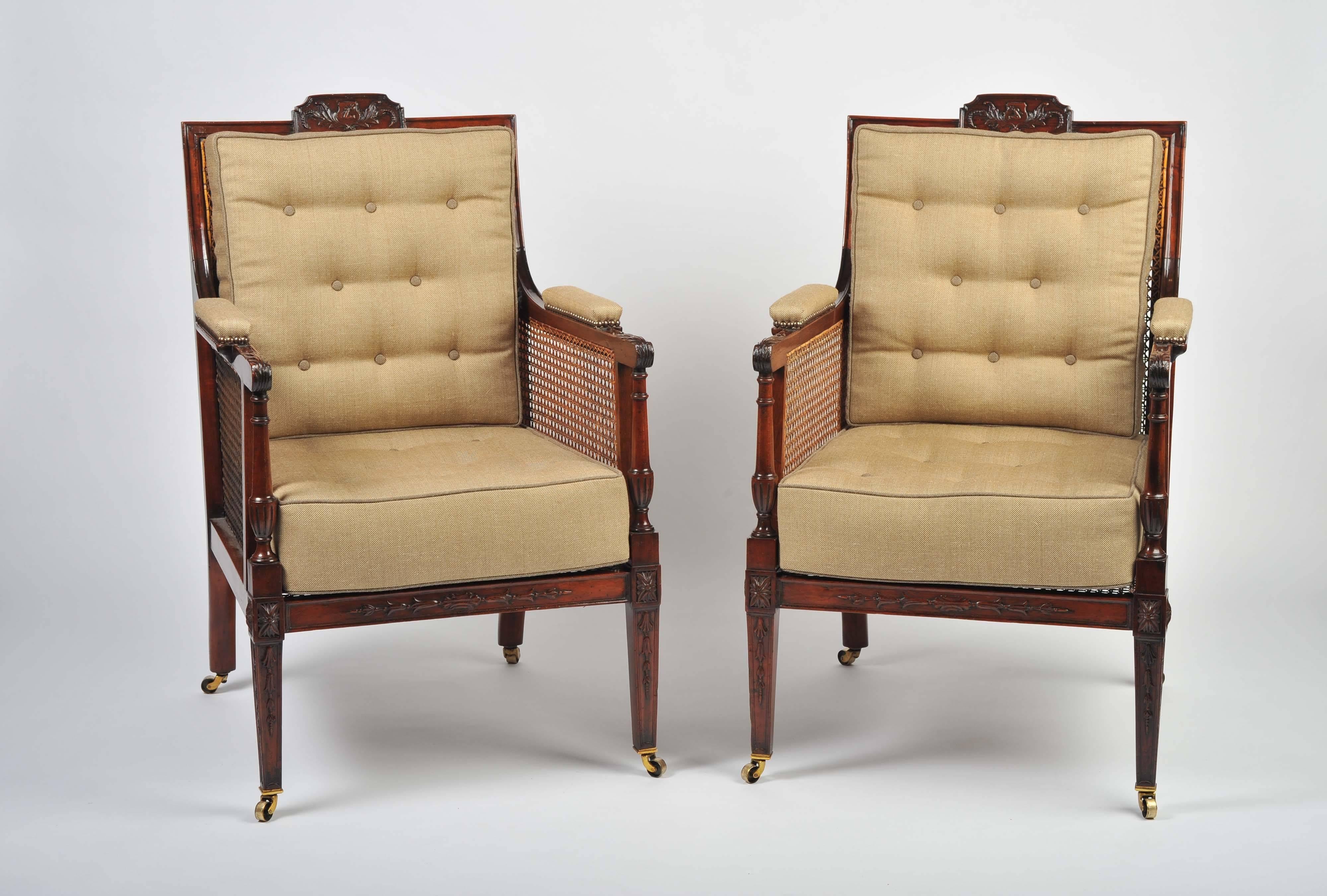 A superb pair of library chairs in the classical style with caned seats, sides and backs. The mahogany frames with finely carved decoration to the crested entablature top rail, arms and front legs.
The armrests padded and the cushions handmade in