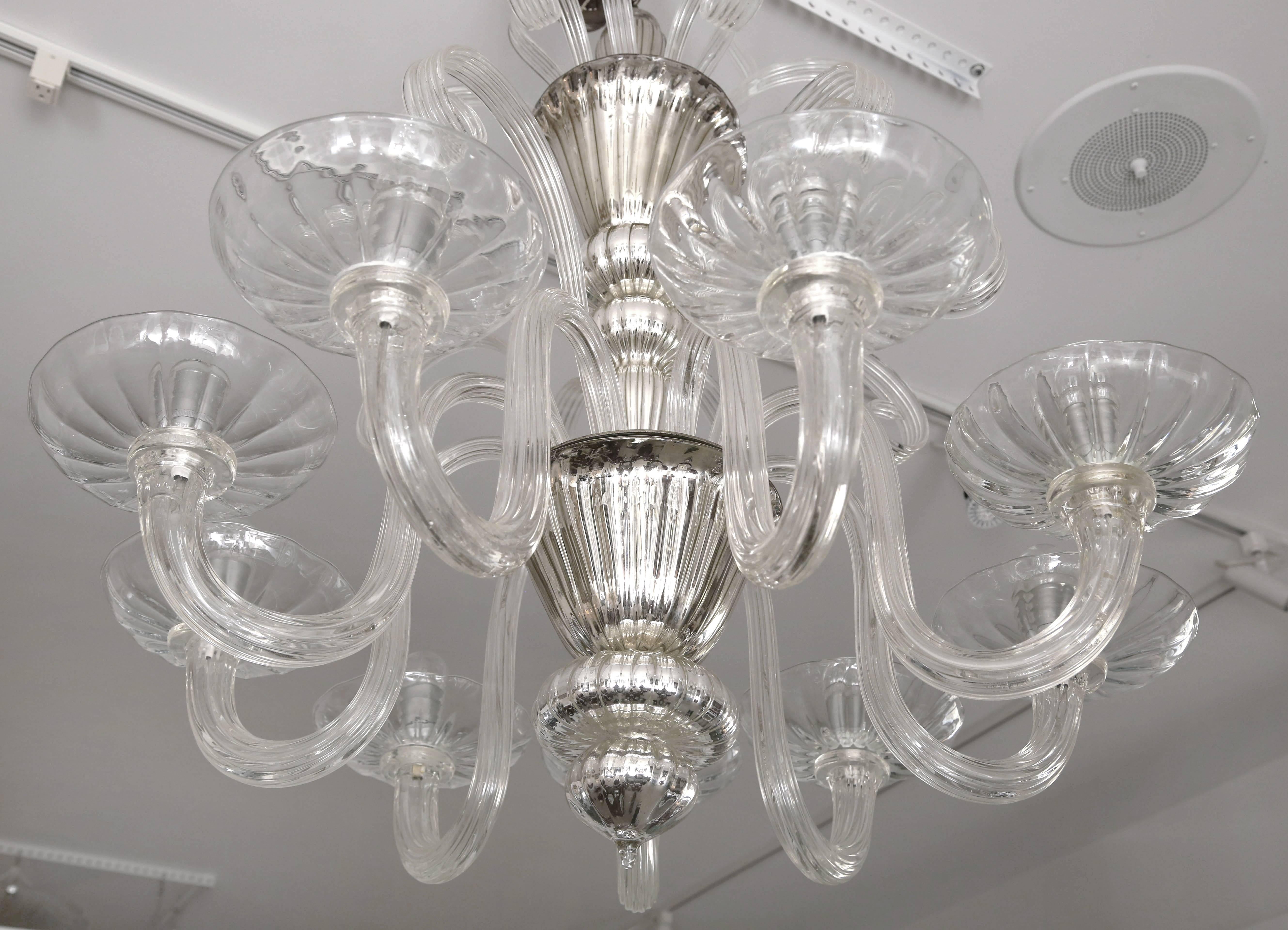 This stylish, large-scale, nine-light Venetian glass chandelier dates from the late 1930s to the early 1940s and is fabricated in clear and mercury or silver glass. 

Note: There is one of the smaller plume or feathers missing see image #7 showing