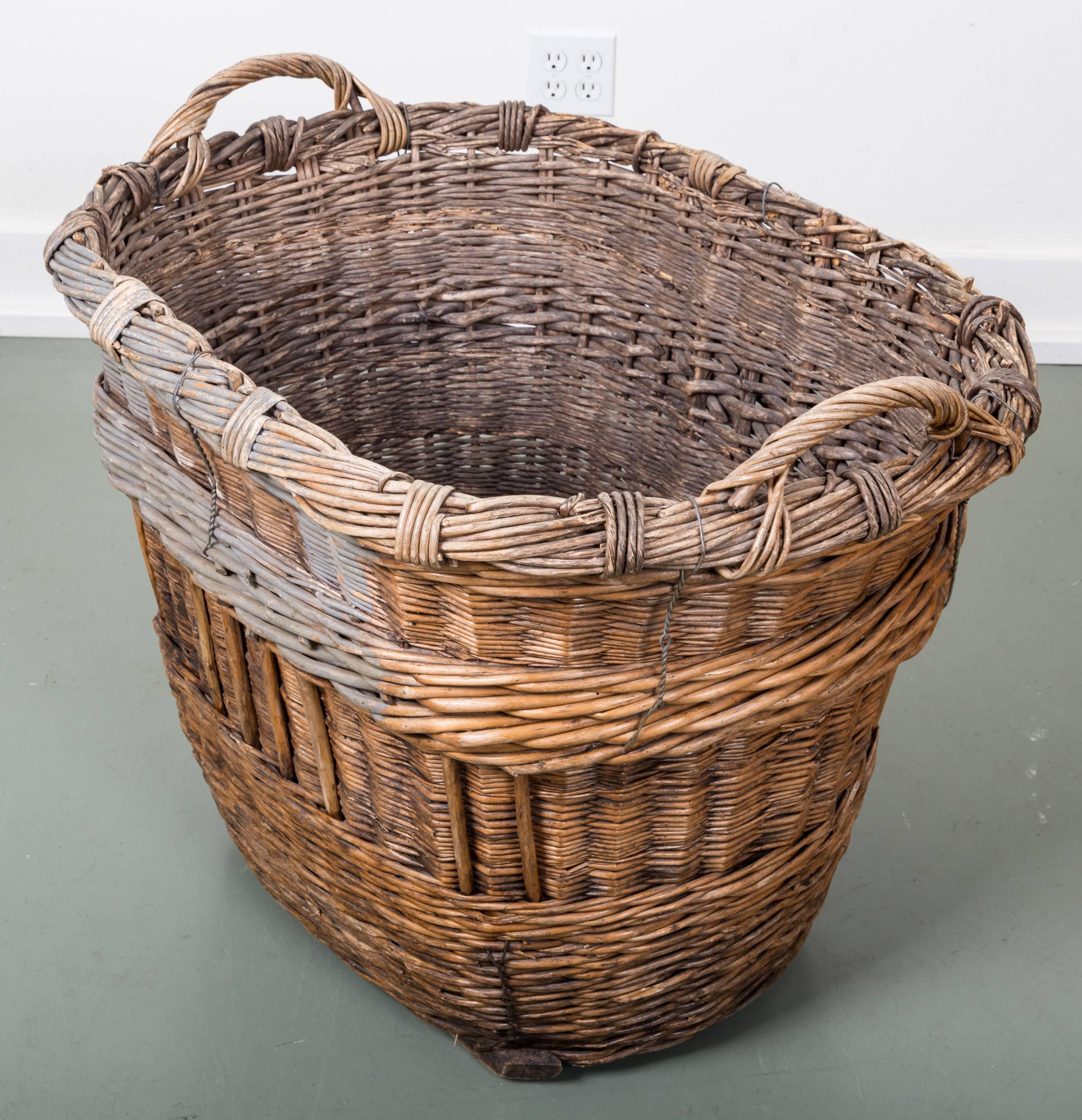 Antique French champagne harvest basket. Woven wicker with twisted wire supports. Two handles, wonderful patina to wicker with original paint color distinguishing vineyard; on two wooden runners. Place of origin Reims, France, circa 1910.