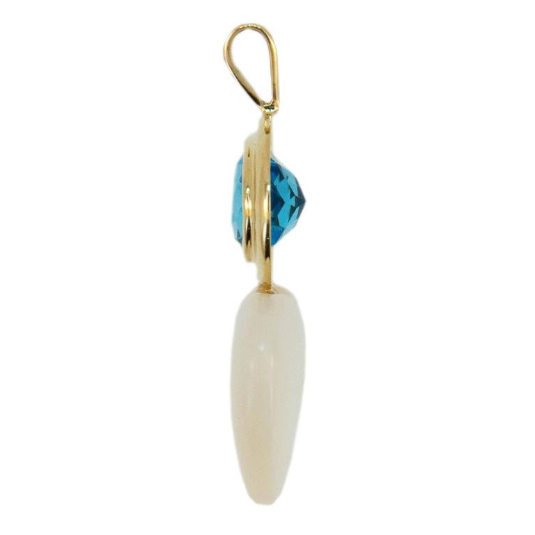 18k yellow gold pendant set with one oval faceted approximately 10x8mm Blue Topaz weighing 3.22cts. and one 15mm heart shaped Mother of Pearl.