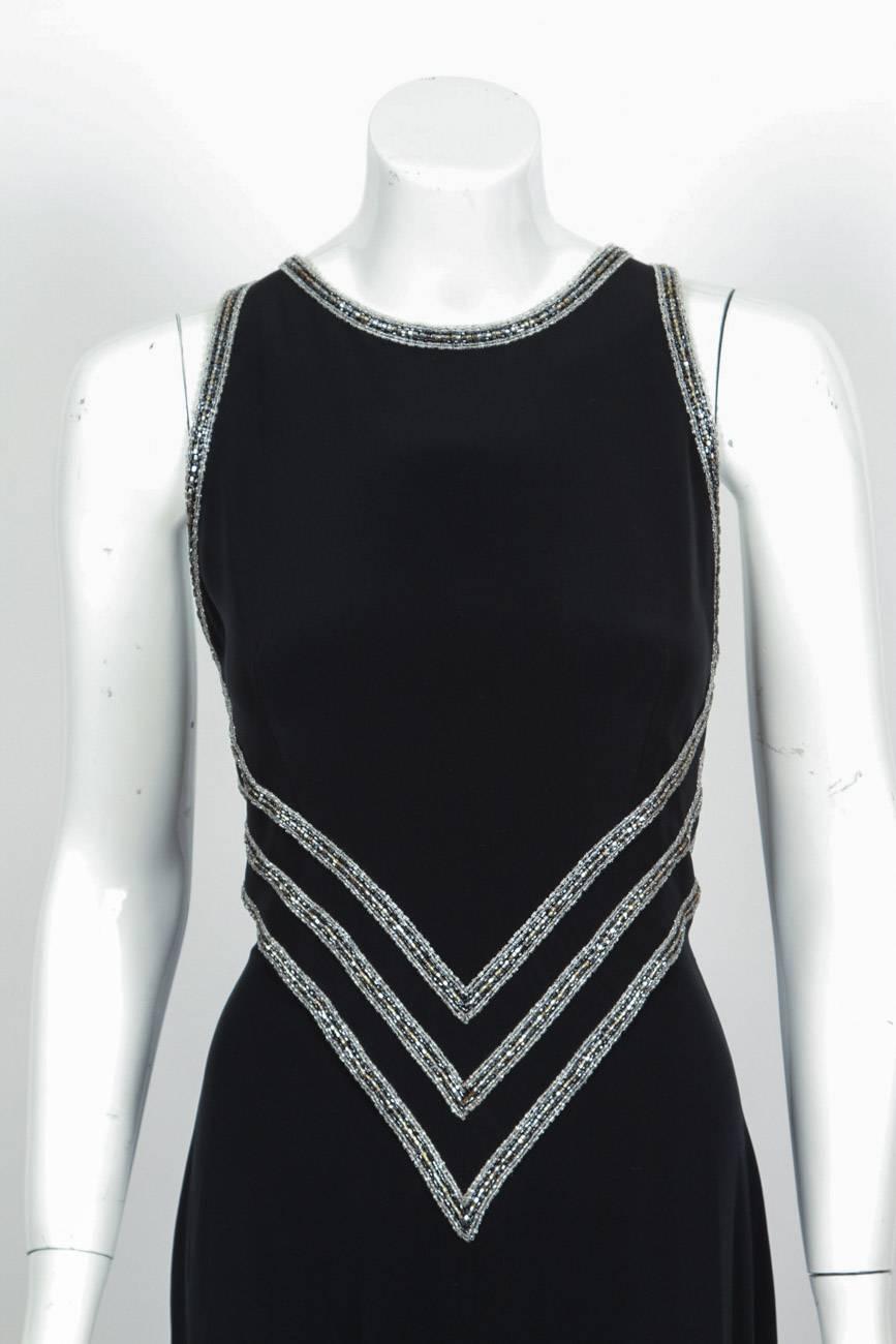 Bob Mackie black silk sleeveless evening gown with an open back, intricate bugle beading at front waist, bodice trim, back, neck, and small train at the back. The dress is in very good condition but there are some holes at the hem of the train where