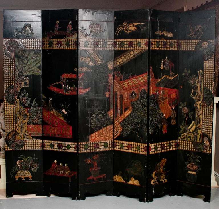 An extraordinary six-panel Chinese carved and lacquered Coromandel screen highly decorated on both sides.