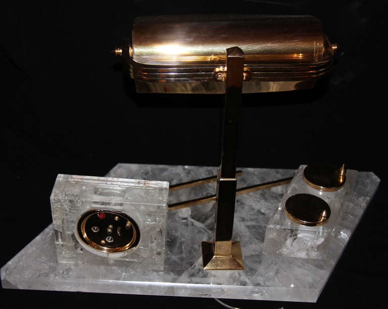 An Art Deco bronze inkwell set with a rock crystal base, circa 1930. Including of two bronze inkwell, adjustable lamp and a clock.