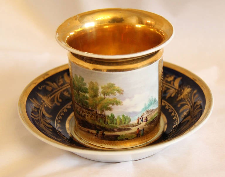 A 19th Century Russian Porcelain Coffee Cup and Saucer, representing a Russian Landscape with People. Marked with a G on the bottom of the cup and saucer.  The word GARDNER (In Russian Cyrillic) is impressed into the porcelain.

Moscow Russia