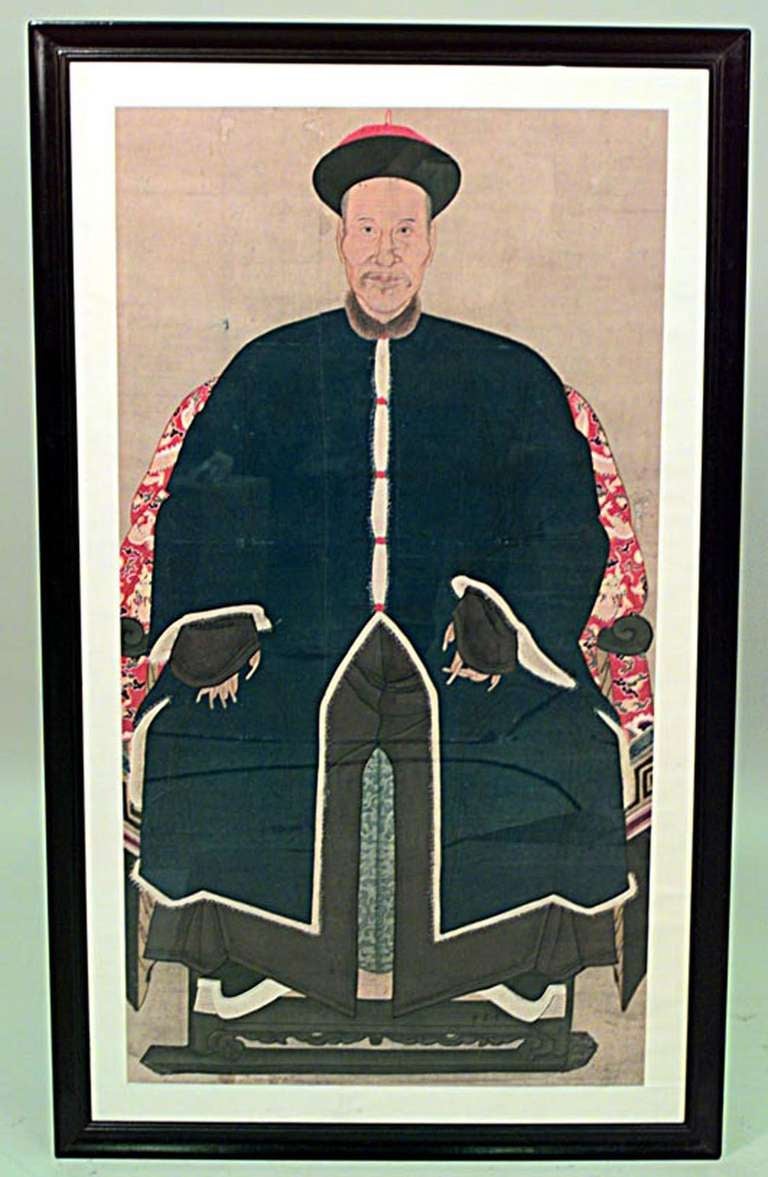 Pair of nineteenth century Chinese watercolor ancestor portraits painted on scroll paper and mounted in simple black lacquered frames. Juxtaposed, the portraits depict an aged but richly dressed couple seated in the foreground against a nondescript