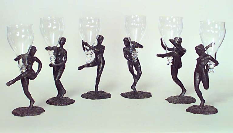 Signed by the French artist LaRoche, this set of six Art Moderne wine glasses is composed of stemless crystal tops each supported by a textured bronze stem cast in the shape of a female form uniquely positioned upon a circular base.