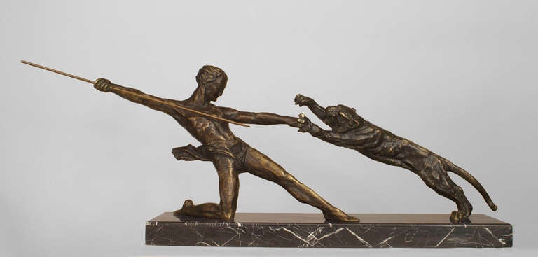 French Art Deco bronze group of a kneeling gladiator poised to spear a charging panther on a black marble base (signed: MICHEL DECOUX, bronze)
