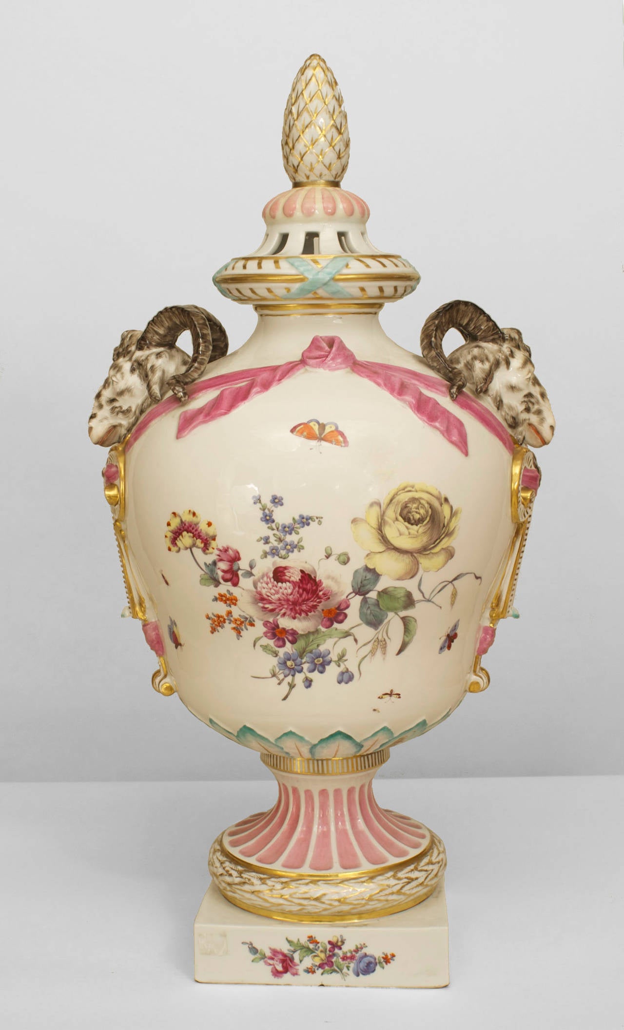 Continental German (Berlin, late 18th Cent) porcelain pink and white decorated urn with a finial top cover and ram head sides, signed on bottom