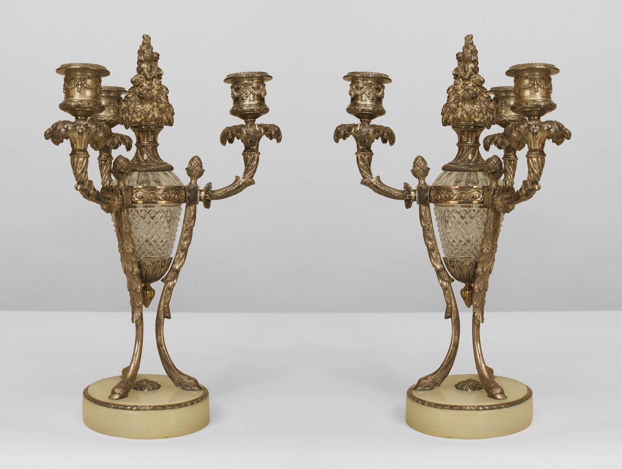 Pair of French Victorian-style silvered bronze and cut glass three-light candelabras resting on a round onyx base. (PRICED AS Pair)
