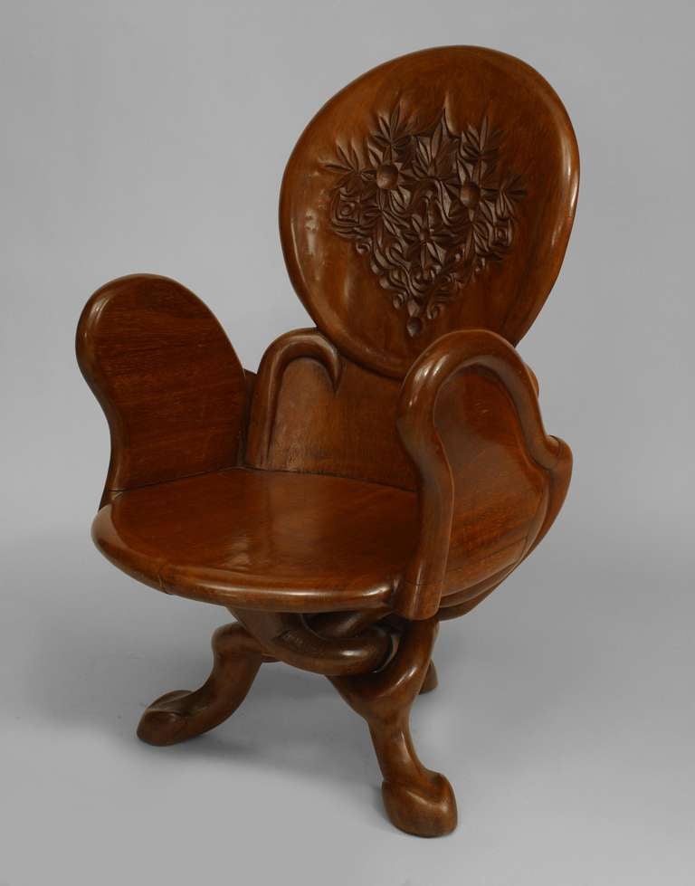 6 Art Nouveau (19/20th Century) teak arm chairs with scroll arms and round back with floral carved medallion supported on 3 intertwined legs. manner of GAUDI. (PRICED EACH)
