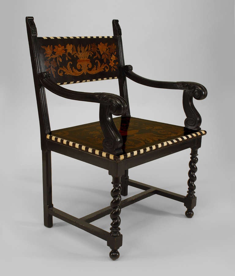 Turn of the century open armchair composed of ebonized wood carved decoratively at its scrolling arms and swirled front legs.The chair achieves additional visual interest with its contrasting bone trim and russet inlaid floral marquetry.