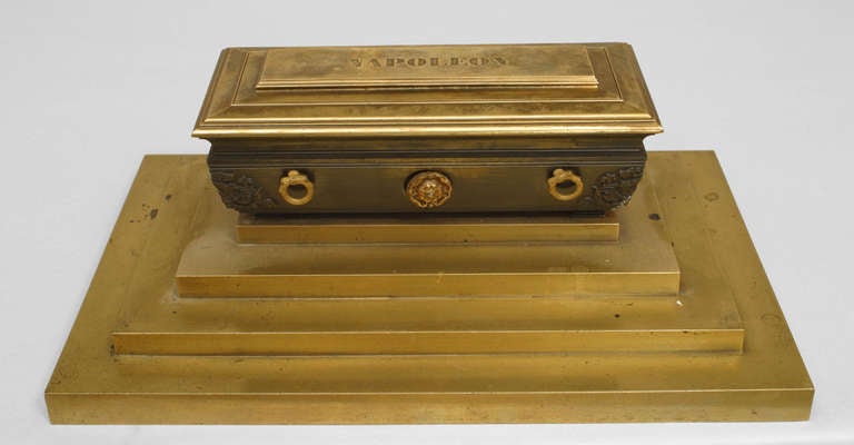 French Empire (19th Century) bronze inkwell in the form of Napoleon's casket covered by a shroud with a crown finial top and resting on a tiered base with a navy velvet lined, three-compartment interior.
