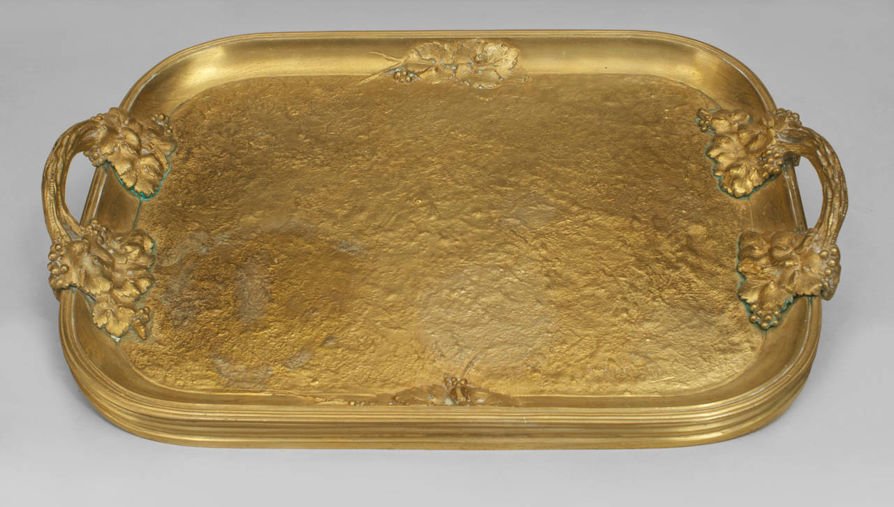 French Art Nouveau gilt bronze serving tray with side handles and floral design with a fluted edge (signed: MARIONNET).
