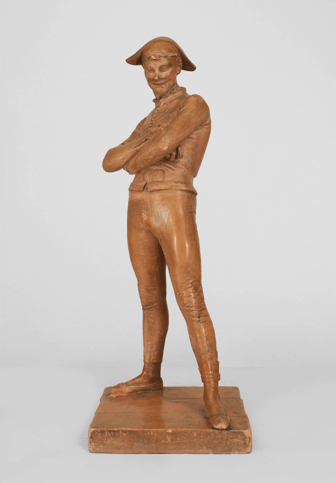 French Victorian (19th Cent) terra-cotta standing figure of a harlequin posing with arms crossed (signed ST. MARCEAUX 1879)
