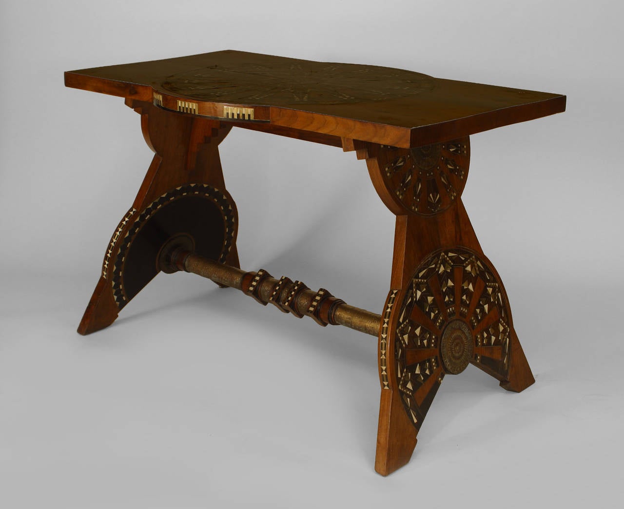 Designed by Carlo Bugatti, this 1930s Italian Art Deco center table is composed of rosewood and features a rectangular top decorated with a pewter, brass, bone, and ebony inlaid sunburst above a trestle base wrapped in embossed brass.