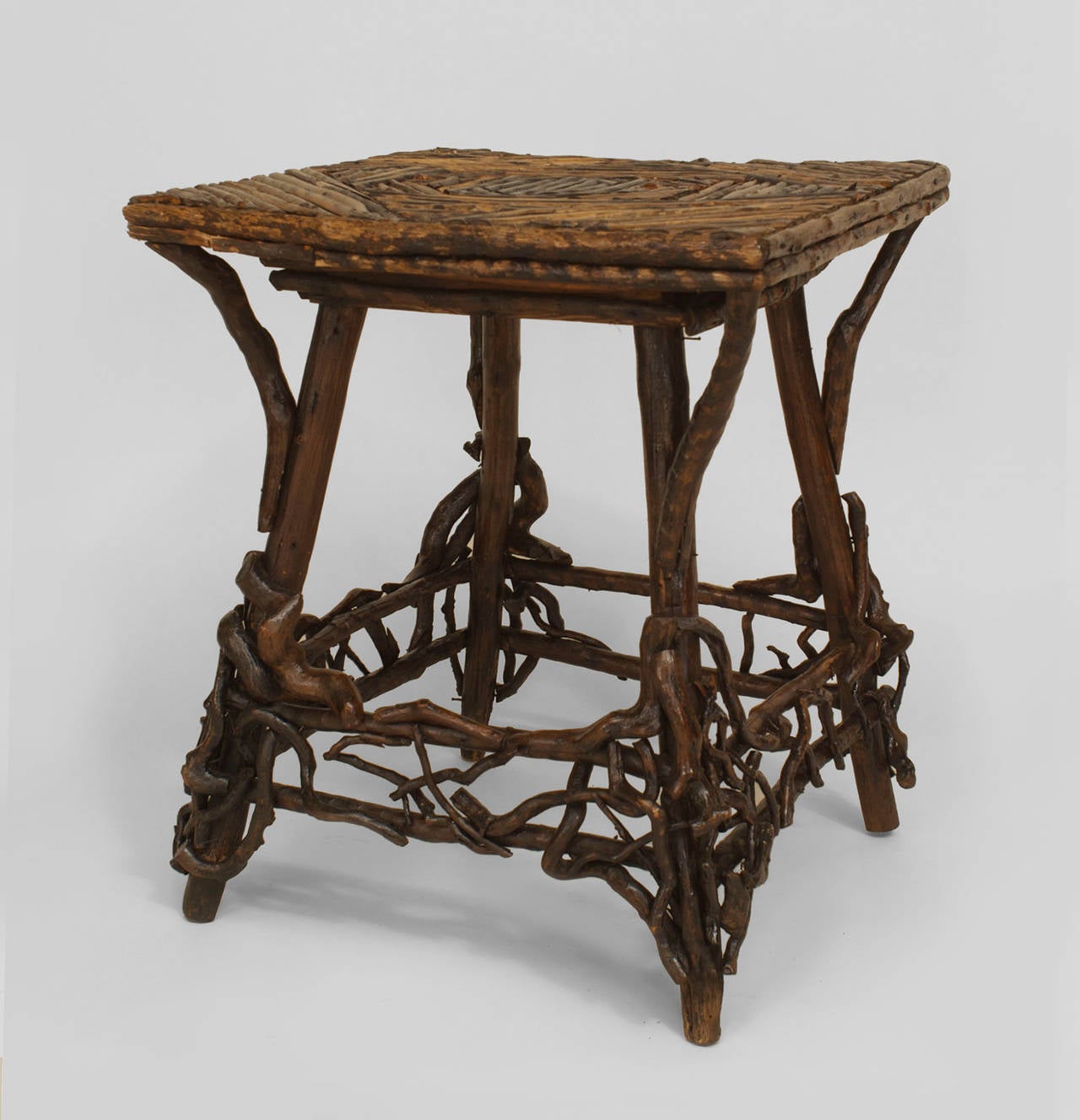 Early twentieth century Rustic Adirondack twig design square end table with a
geometric slat design top and a box form stretcher surrounded by root trim.