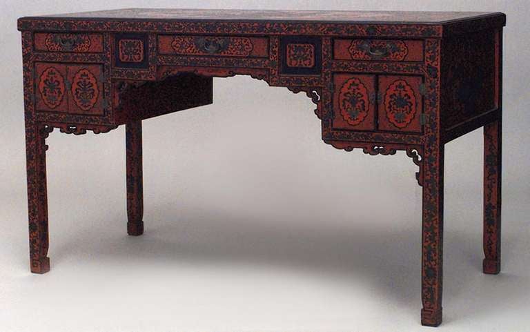 Nineteenth century English Regency desk composed of red lacquered coromandel heavily decorated Chinoiserie desk designed with a number of drawers and doors concealing storage.