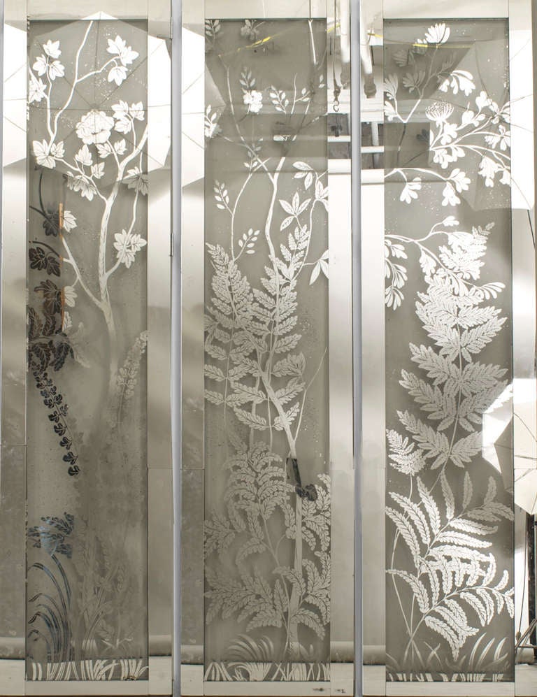 1940's American Art Moderne folding screen with six panels, each featuring panes of glass decorated with floral etched silver and framed in mirrored glass. Each panel measures 23 inches wide.