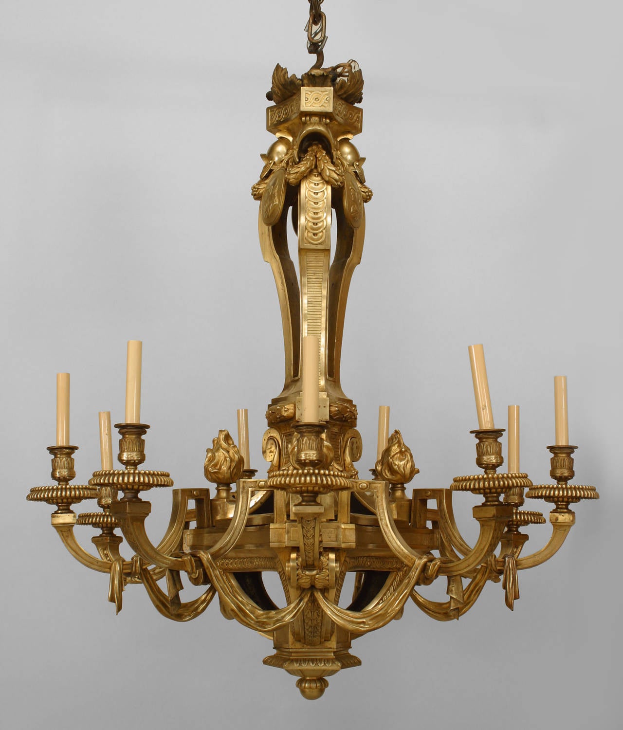 19th century French Louis XVI style bronze doré twelve-arm chandelier with arms joined by a swag design beneath a flame top.
