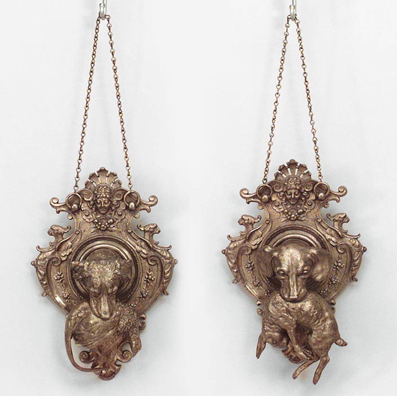 Pair of 19th century French shaped bronze wall plaques, each showing dogs' head holding game in its mouth, a bird and rabbit, respectively.