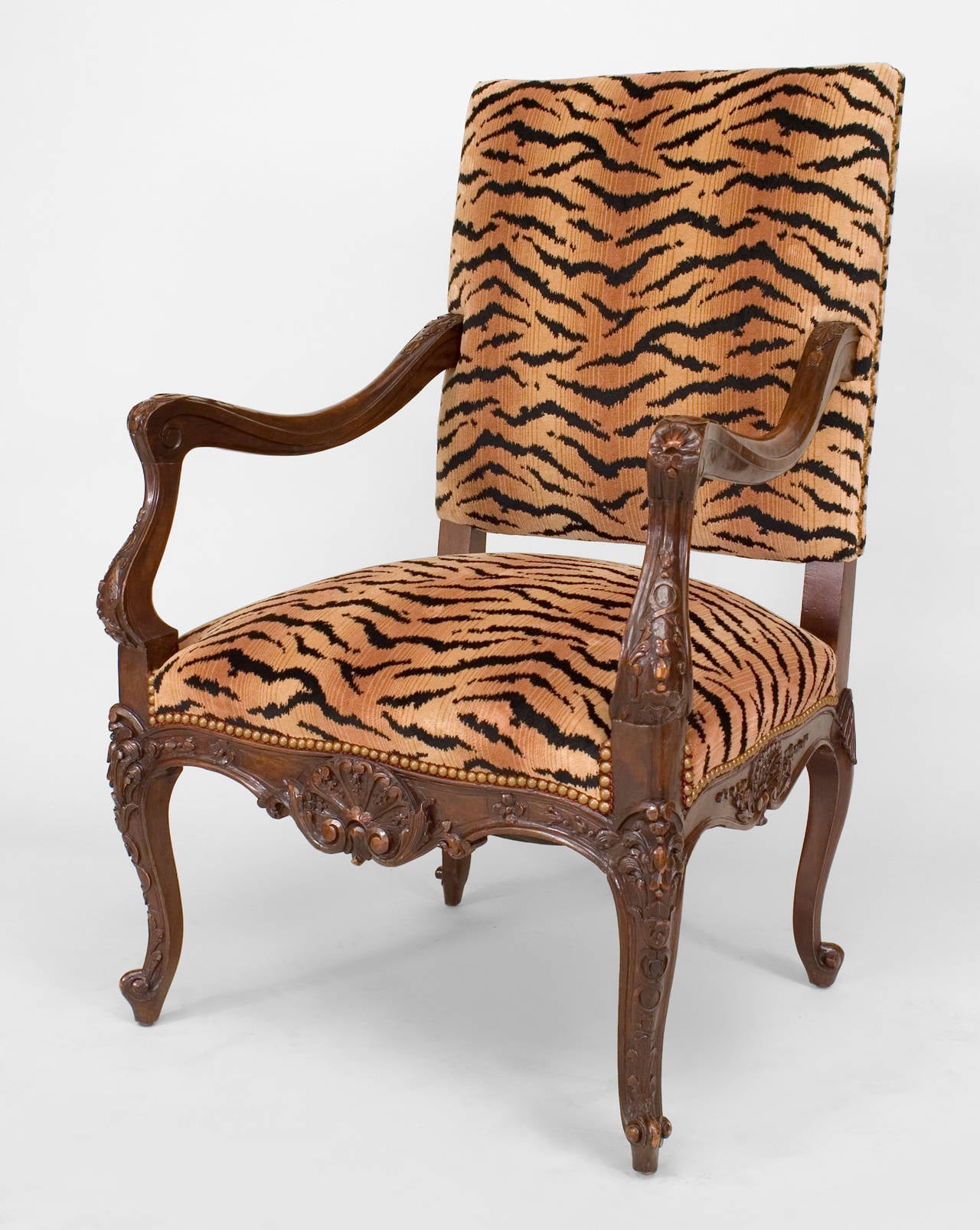 French Regence style (19th/20th C) carved walnut open arm chair with faux tiger upholstered seat and back.

