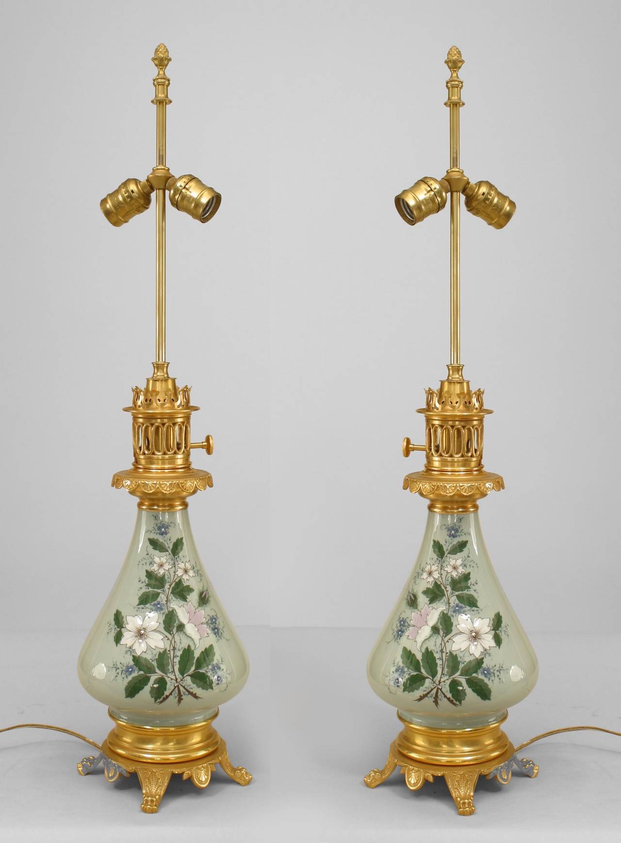 Pair of French Victorian porcelain pate-su-pate celadon lamps with floral decoration and gilt bronze base and trim. (Originally oil now wired for electric)(PRICED AS Pair).
