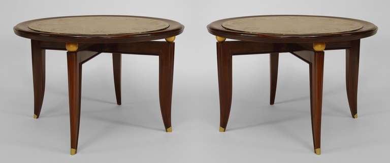 Pair of French Art Deco low end tables composed of rosewood with round tops inset with etched mirror tops decorated with a gilt floral and scroll design supported by four gilt balls over a stretcher and four legs with brass sabot feet.