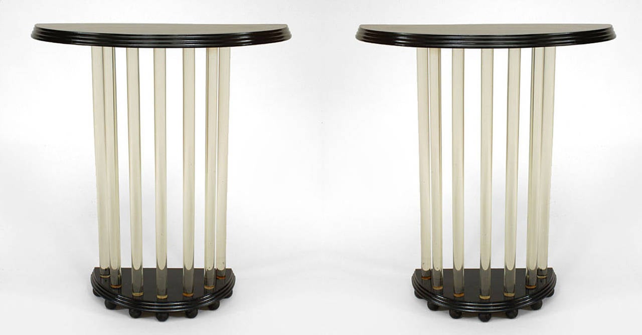 Attributed to Betty Joel, pair of 1940's English black lacquered console tables, each with seven tubular glass rods supporting a demilune-shaped top and resting upon a base raised on small spheres.