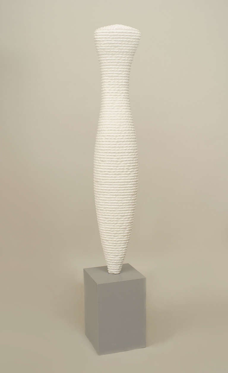 Large American white cement porcelain sculpture of a vertical ridged form mounted on a grey plaster base.