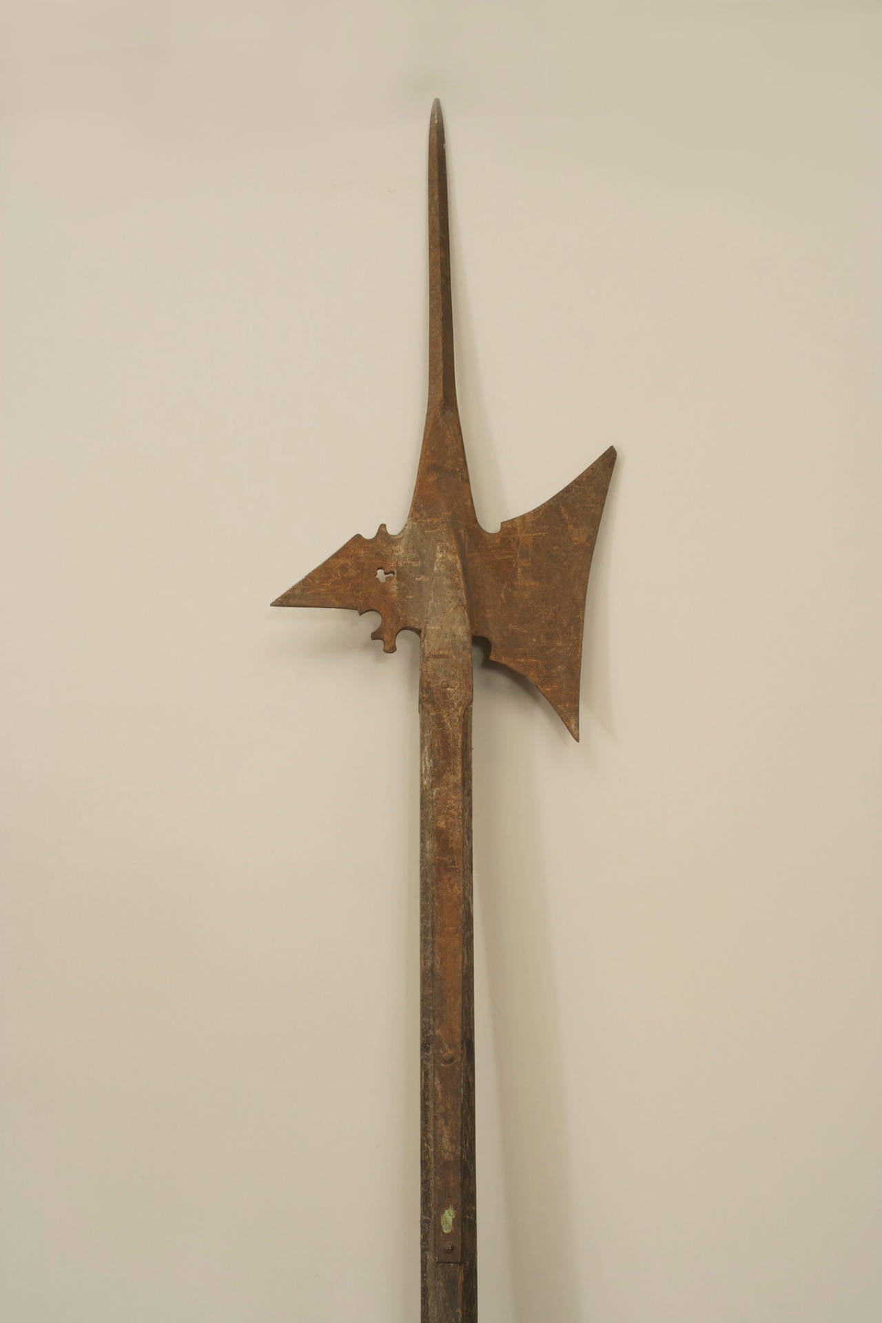 English Renaissance-style halberd spear with eight-sided wooden shaft with nail heads and an iron ax-shaped blade.
