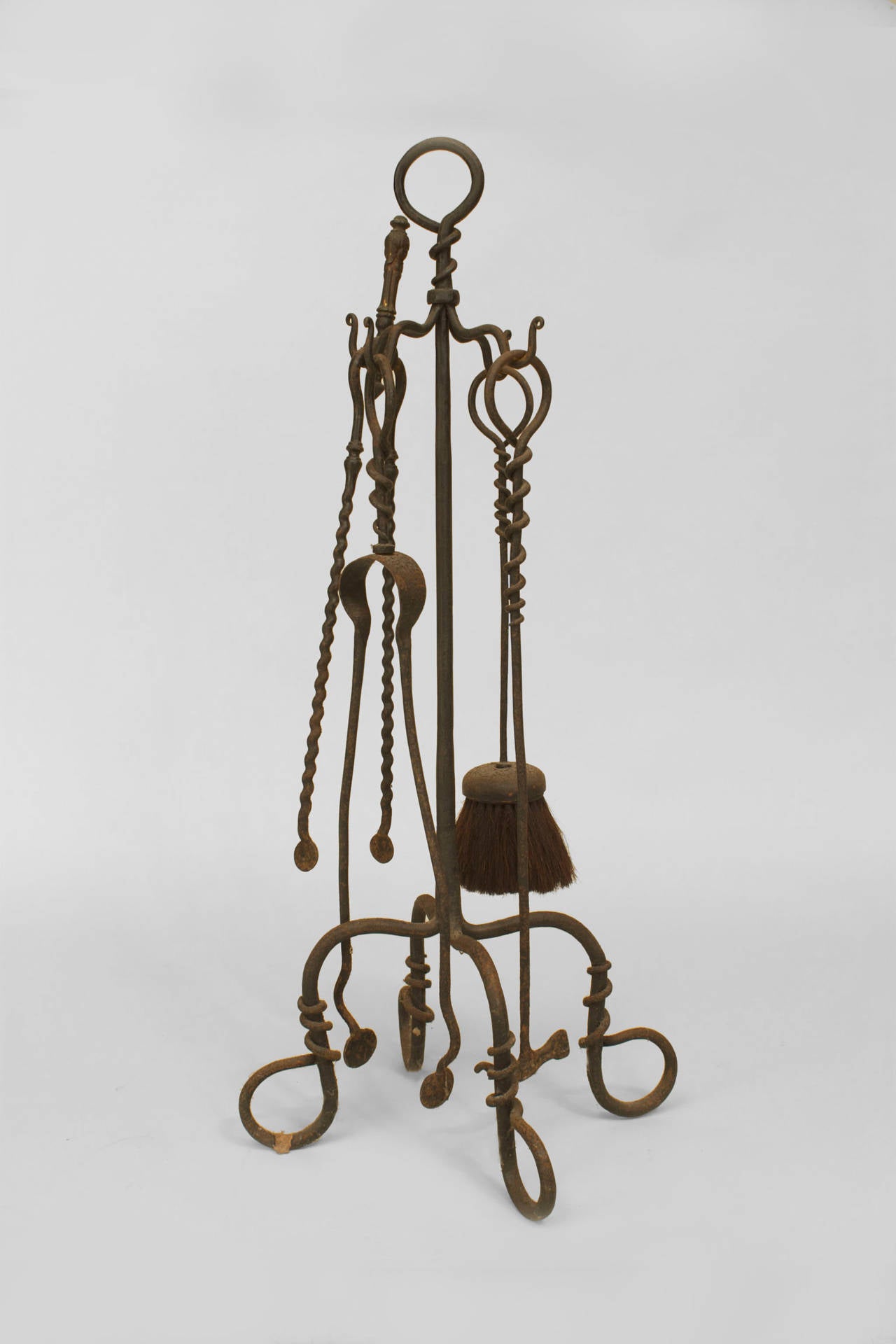 Set of 4 American Mission-style (Early 20th Century) wrought iron fire tools on a stand with 4 scroll base feet and ring top.
