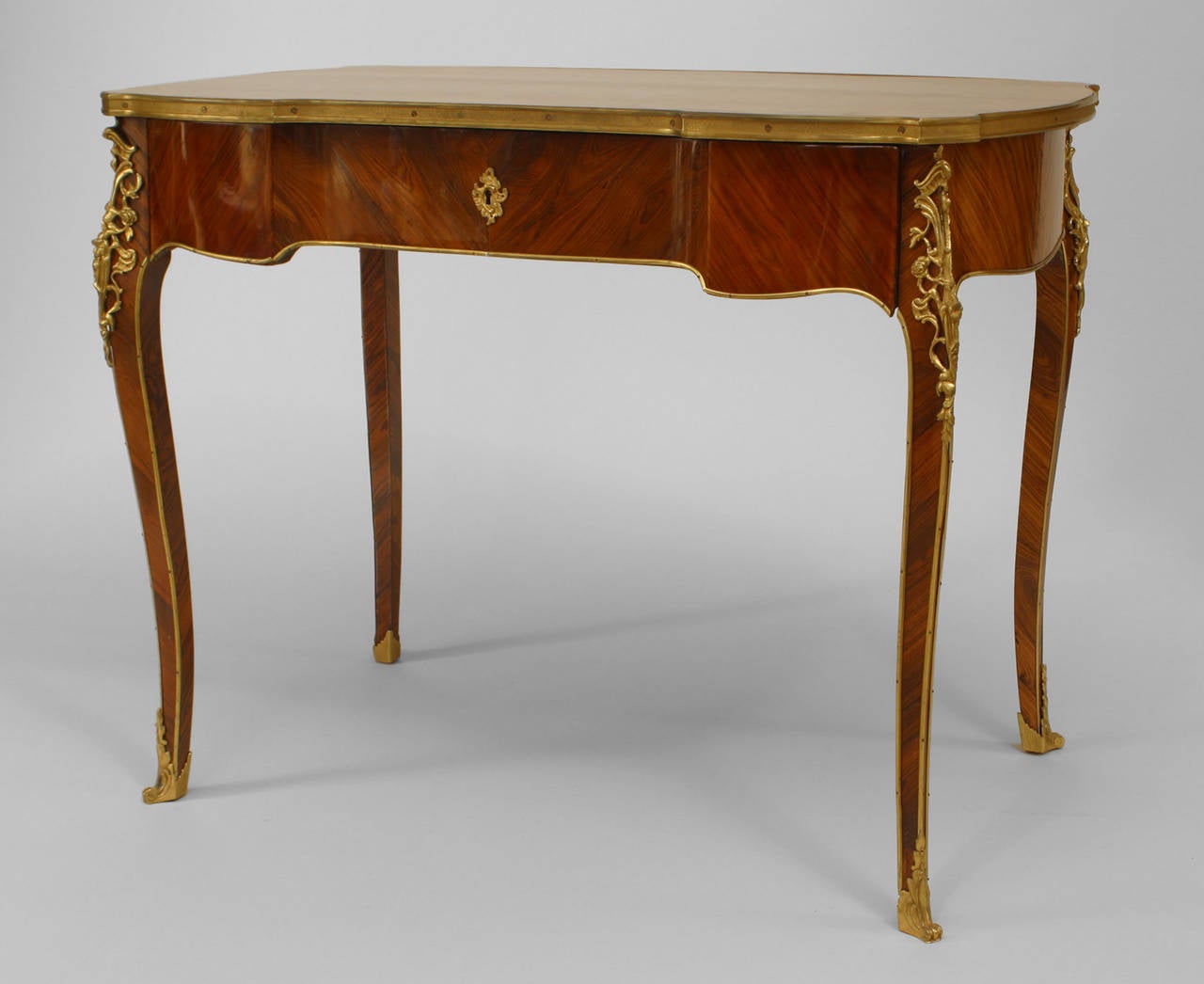 Scrivania francese in stile Luigi XV (XX secolo) con piano intarsiato in parquet e finiture in bronzo dorato con un unico cassetto.
