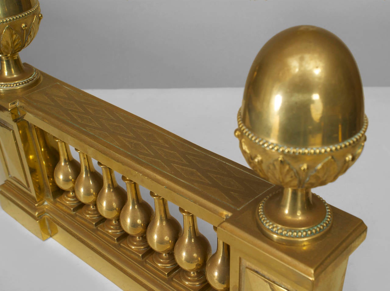 Pair of English Adam-style (19/20th Century) brass balustrade design andirons with large finial sides. (PRICED AS Pair)
