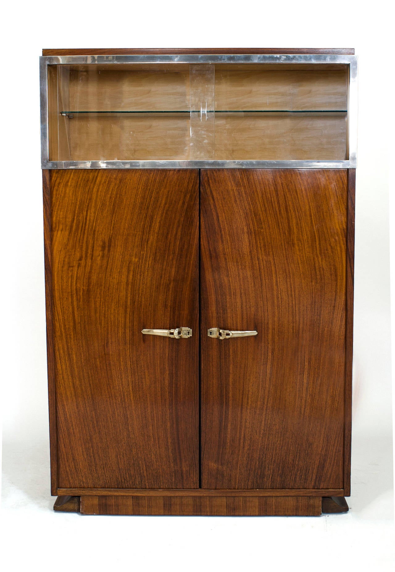 French Art Deco rosewood vitrine/bar cabinet with to glass top sliding doors framed in chrome above to large doors with brass decorative handles (branded: DOMINIQUE, PARIS)
