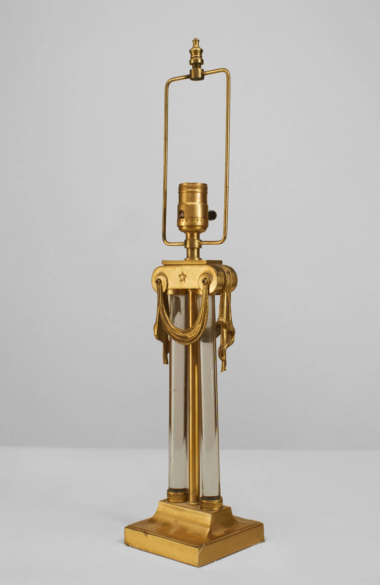 Pair of American Art Moderne brass & glass table lamps with swag hung capital above Paired glass cylinders (PRICED AS Pair).
