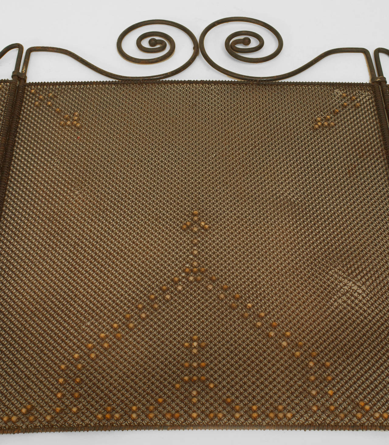 American Mission wrought iron low fire screen with a scrolling design top and
mess panels decorated with a beaded design.