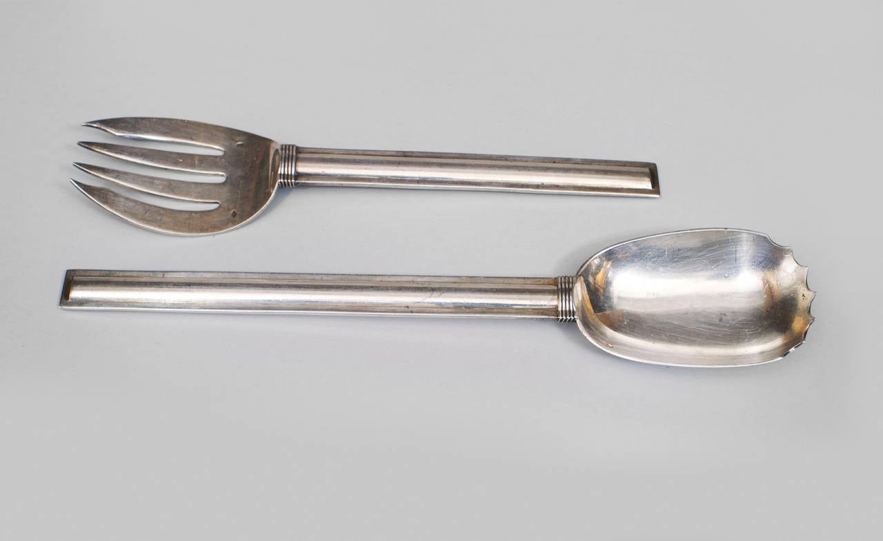 Signed Jean E. Puiforcat, an assorted set of 8 French Art Deco sterling silver service utensils, including a pair of spoons, a pair of serrated spoons, a cutting knife, fork, vegetable fork, and butter spread.