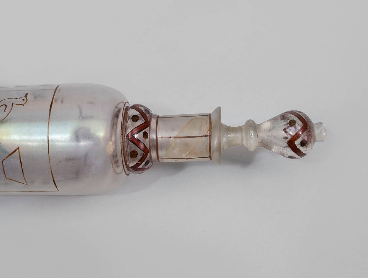 1920's Egyptian Revival cylindrical glass perfume bottle with decorated with classicizing painted enamel motifs.