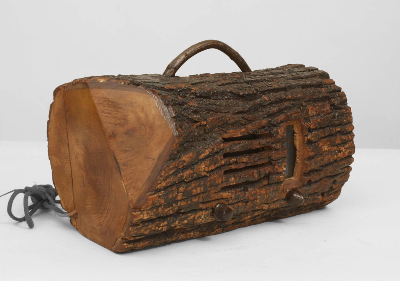 Rustic American Adirondack-style (1930s) radio in a the form of a log with bark exterior and a handle.
