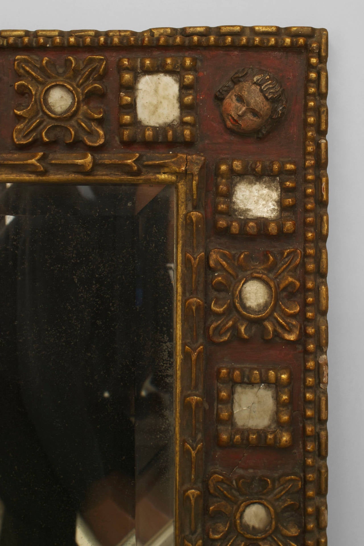 19th century Spanish Renaissance style wall mirror of probable Mexican origin. The mirror features a gilt carved frame with corner masks and inset glass panels.