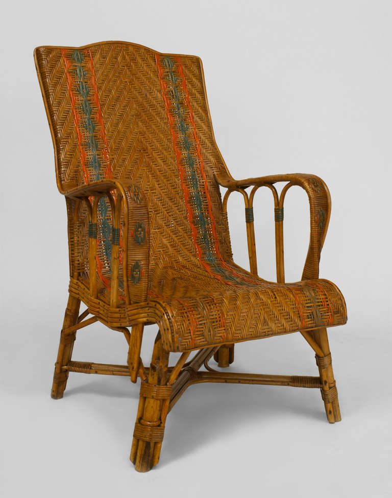 French Art Deco continuous armchair with a high square back and four splayed legs joined by an intersecting stretcher. The chair is composed of natural wicker woven in a chevron pattern and decoratively highlighted in green and red paint.
